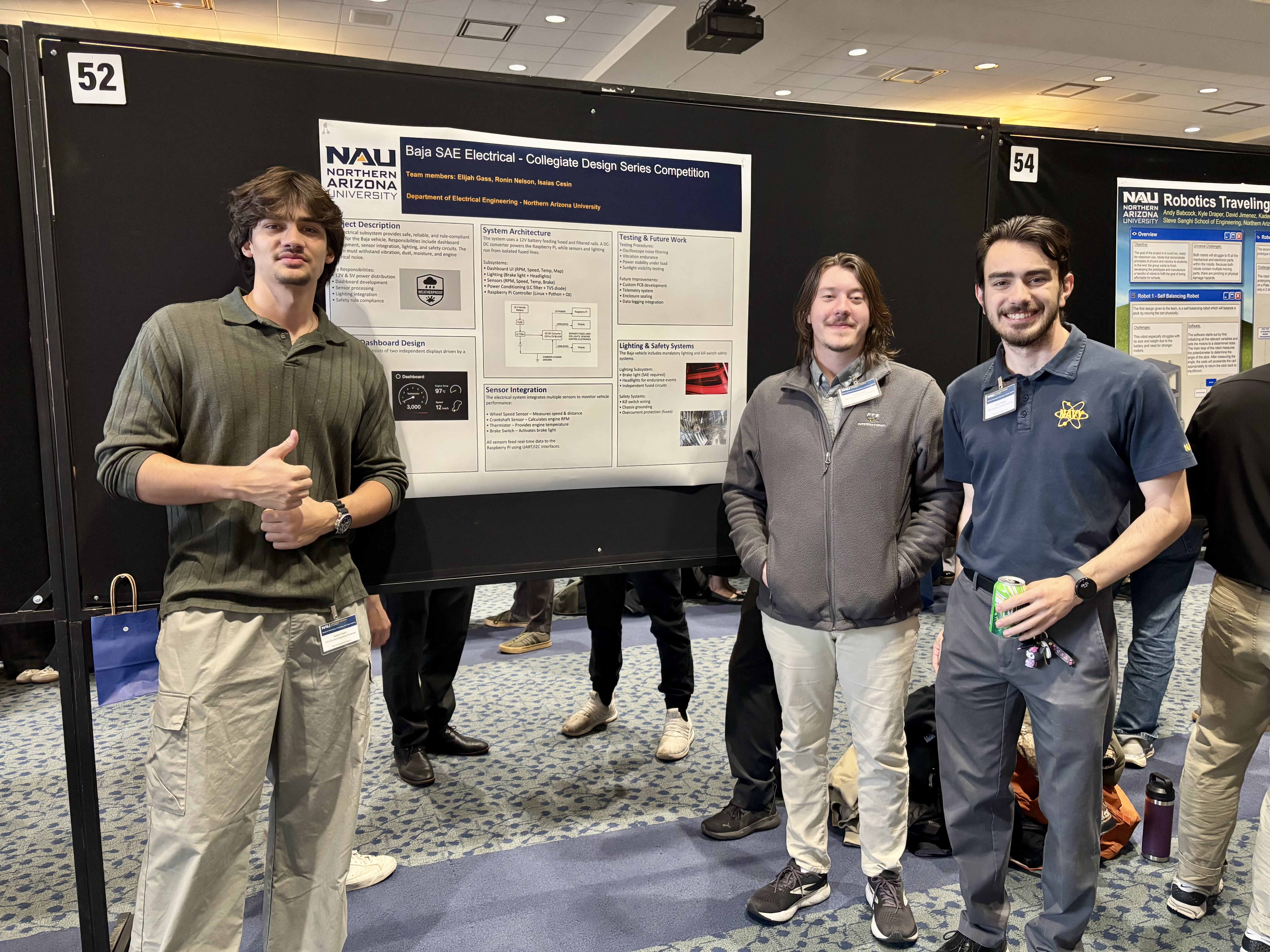 NAU Baja SAE Electrical team standing in front of their project poster at the capstone session.